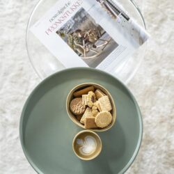 Klassiek theelepeltje en chocoladekoekjes op Mokana meubelen bijzettafel voor gezellige thee- en koffiemomenten.