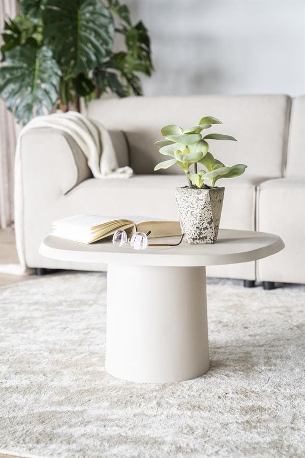 Minimalistisch ronde salontafel met plant en boek in een modern woonkamer, perfect voor stijlvolle en functionele interieurdecoratie.