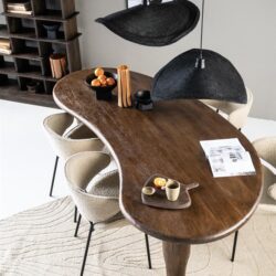 Handgemaakte eiken eettafel met asymmetrisch design en natuurlijke afwerking in een modern interieur.