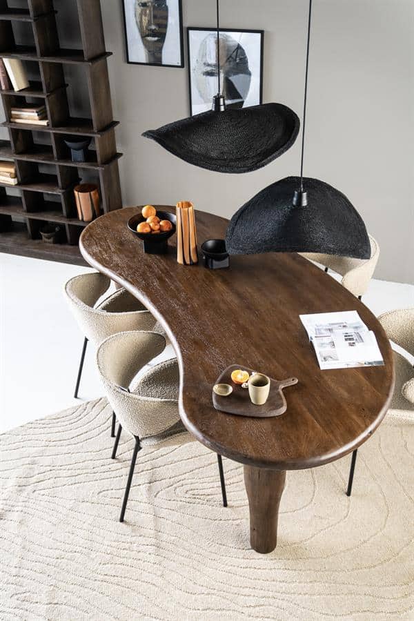 Handgemaakte eiken eettafel met asymmetrisch design en natuurlijke afwerking in een modern interieur.