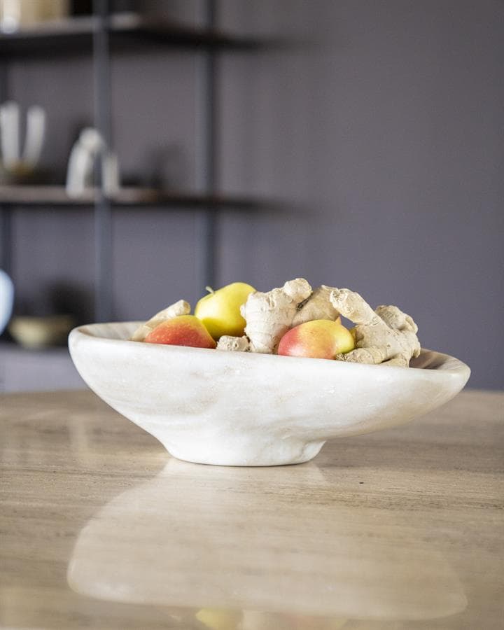 Besloten gember en appels in witte kom op houten tafel, moderne interieurstijl.