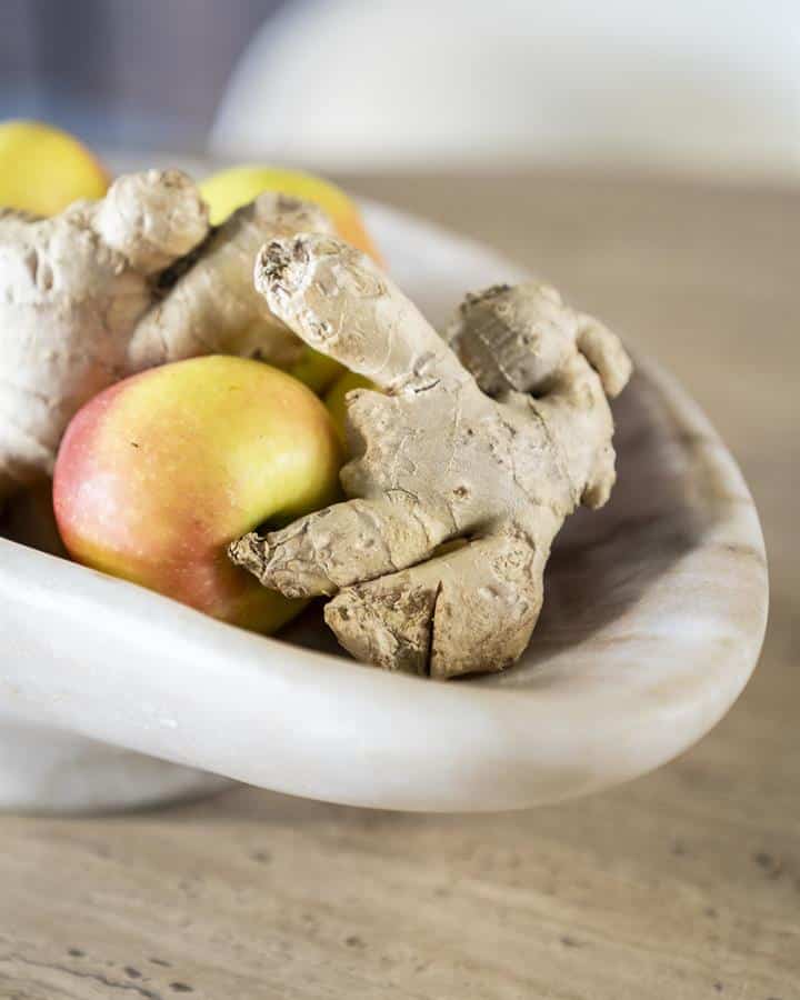 Gember en appel in een witte kom op een houten tafel, seizoen- en keukeninspiratie, natuurlijke gezonde ingrediënten, verse kruiden en fruit, topkwaliteit voedsel.