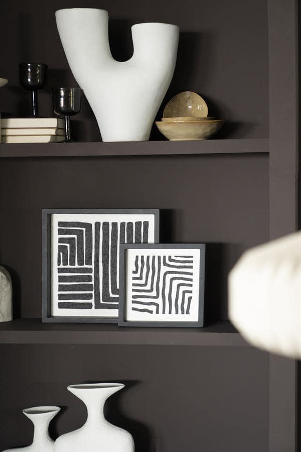 Moderne meubelaccessoires en decoratieve kunstwerken, zoals geometrische prints en unieke vazen, passend bij stijlvolle interieurconcepten.