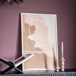 Moderner abstract kunstprint met zachte pastelkleuren en witte lijnen, geschikt voor woondecoratie, vlakbij kaarsen en een boek op een donkergrijze meubel tegen een paarse muur.