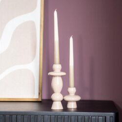 Elegant beige houten kandelaars met kaarsen op zwart dressoir in modern interieur.