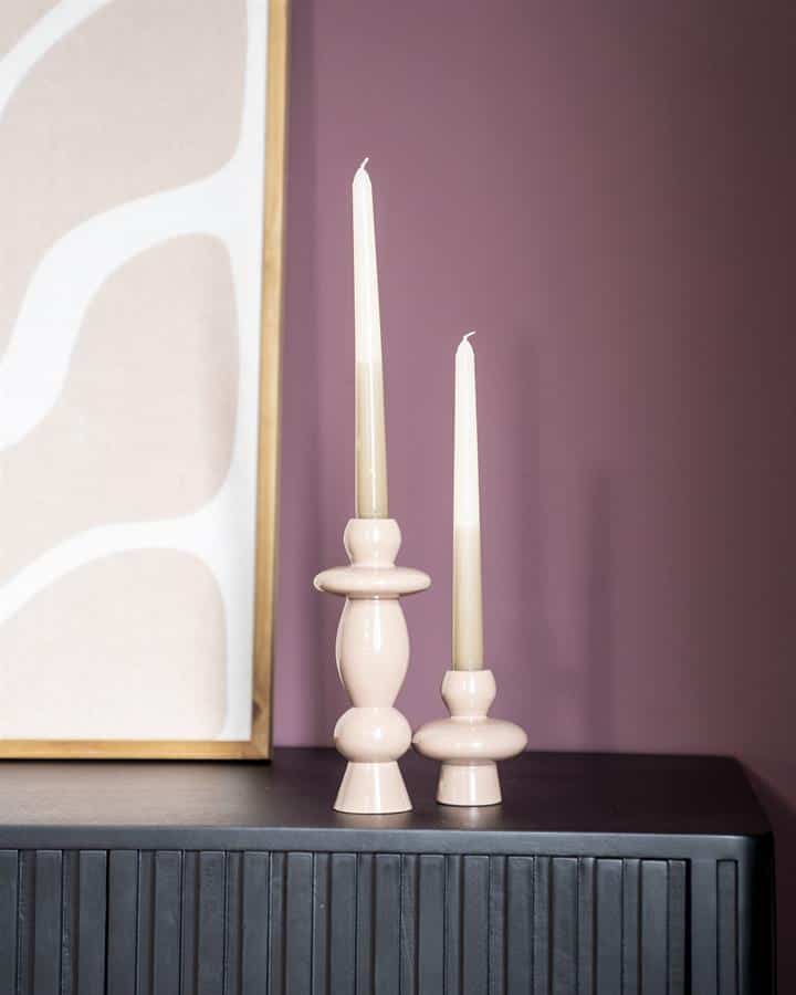 Elegant beige houten kandelaars met kaarsen op zwart dressoir in modern interieur.