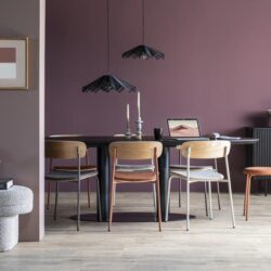 Elegante eettafel met houten stoelen en moderne lampen in een stijlvol interieur met muurdecoraties.
