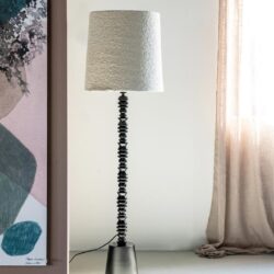 Hoogwaardige vloerlamp met zwart metalen voet en textuurrijke witte lampenkap, modern interieuraccessoire voor woonkamer of kantoor, ontworpen door Mokana Meubelen.