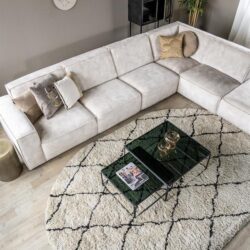 Lichtgrijze hoekbank in een modern interieur met decoratieve kussens en een luxe glazen salontafel, perfect voor een stijlvolle woonkamer.