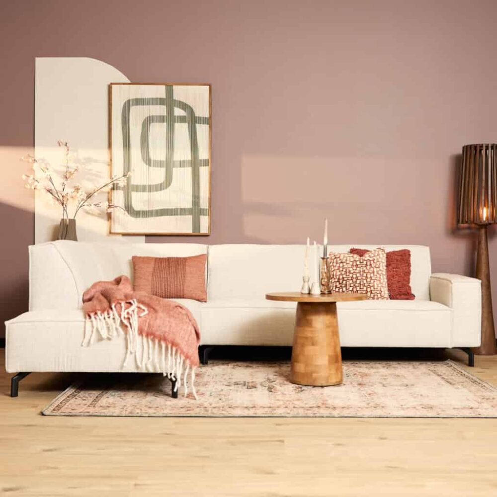 Modern witte bank in een gezellige woonkamer met roze en beige decoratie, houtenvloer en stijlvolle accessoires, perfect voor een warm en eigentijds interieur.