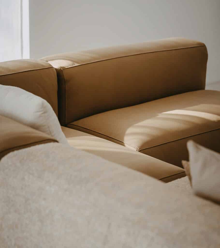 Elegante leren bank in taupe met comfortabele kussens.