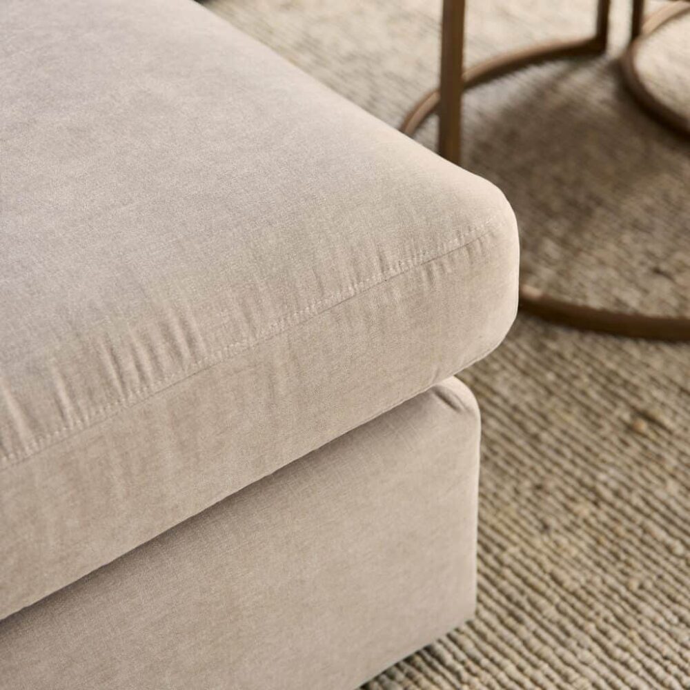 Zachte beige stoffen bank met elegante afwerking, perfect voor een modern interieur.