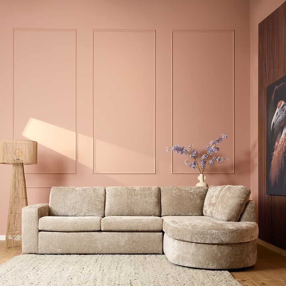 Modern vintage fluwelen L-form bank in beige met zachte kussens, passend bij een hygiënische en stijlvolle woonkamer inrichting.