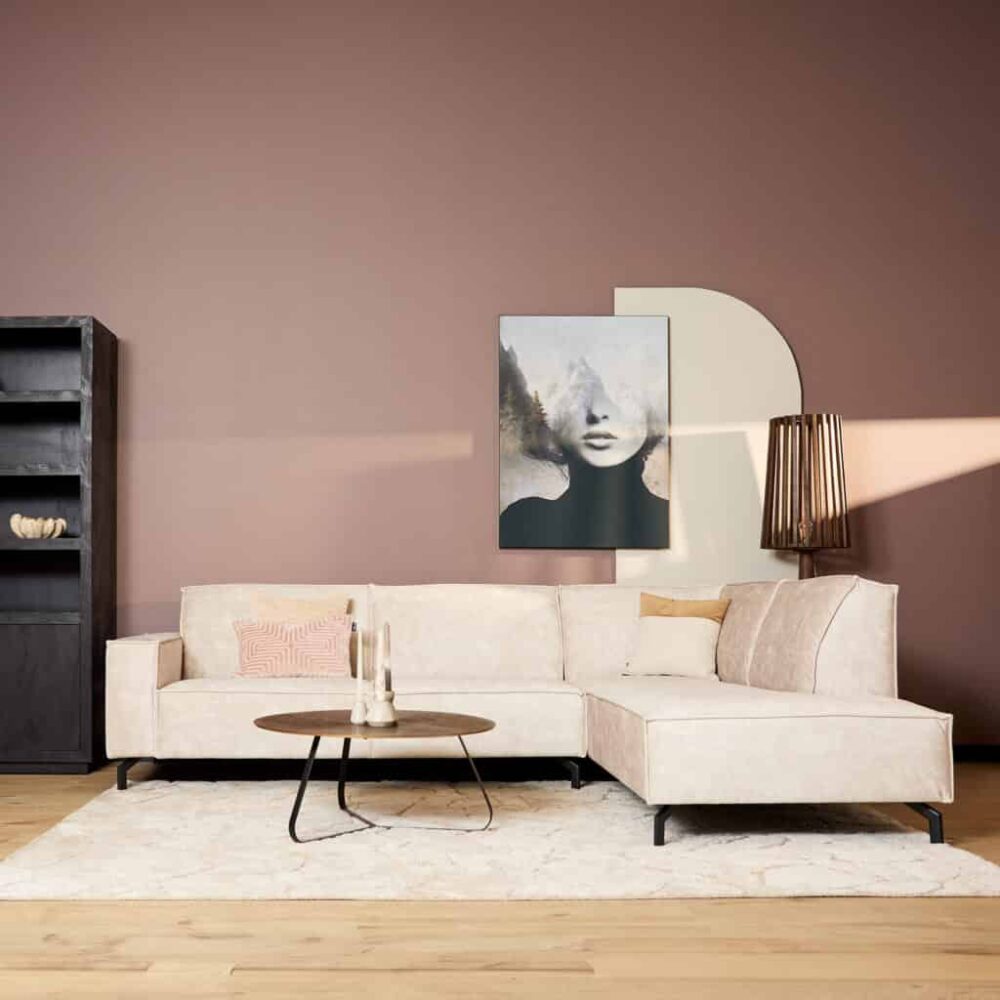 Modern vintage witte hoekbank in woonkamer met landelijke stijl, tapijt en accessoires.