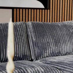 Zwart fluwelen bank met verticale stiknaden en moderne uitstraling, perfect voor een comfortabele en stijlvolle woonkamer decoratie.