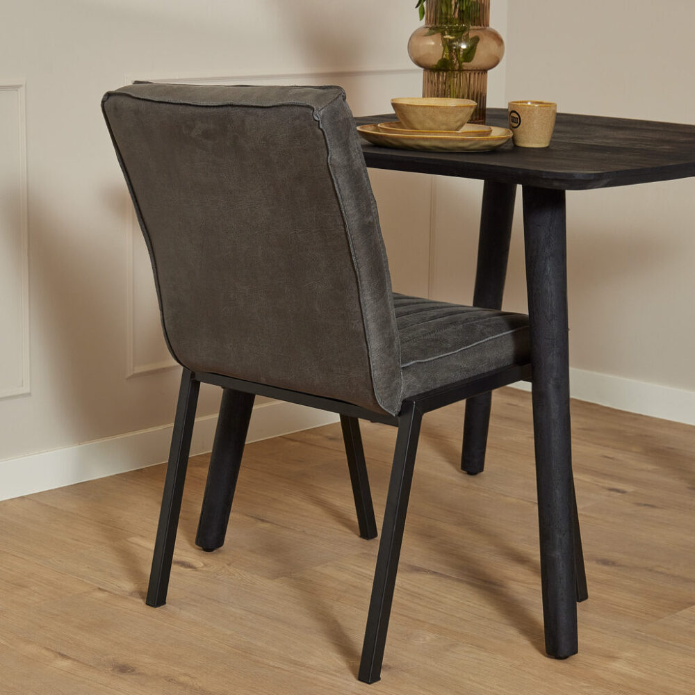 Modern eetkamerstoel van Mokana Meubelen met comfortabele grijze bekleding en zwart houten poten, perfect voor een stijlvolle en gezellige eethoek.