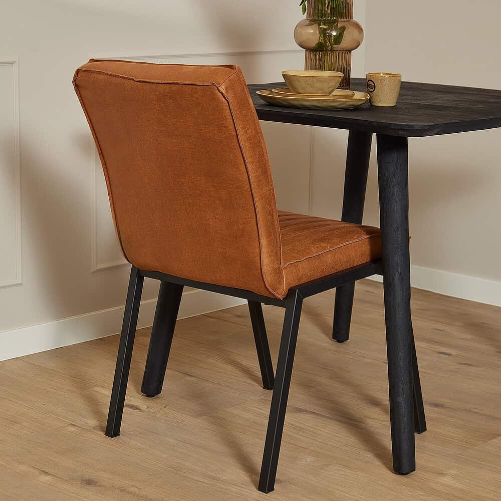 Verrijdbare houten eetkamerstoel met oranje fluwelen bekleding en zwart houten frame, passend bij moderne interieurdesigns en duurzame meubels van Mokana Meubelen.