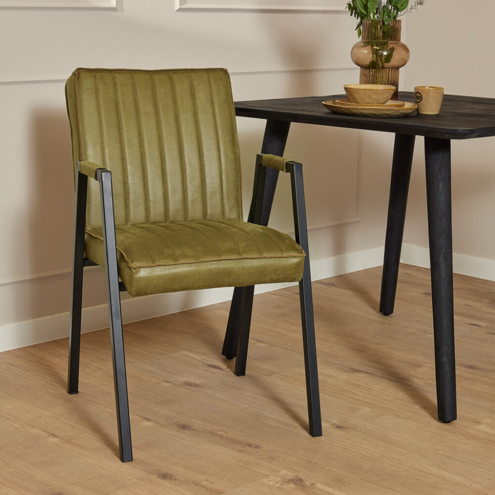 Vintage groene eetkamerstoel met zwart metalen frame en gestikt velvet bekleding, perfect voor modern of retro interieur.