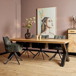 Moderne eettafel van massief hout met zwart metalen onderstel, gecombineerd met comfortabele velours eetkamerstoelen, in een stijlvolle eetkamer met kunst en decoratie.