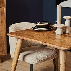 Robuuste houten eettafel met natuurlijke uitstraling, afgewerkt met een warme, natuurlijke houttekening. Perfect voor moderne en landelijke interieurstijlen, gecombineerd met stijlvolle keramische decoratie.