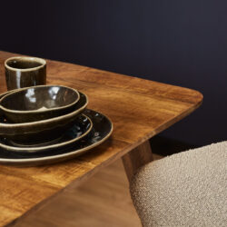 Kunststof servies op houten eettafel, stijlvolle eettafel met keramische kommen en bekers, Mokana Meubelen, hoogwaardige houten eettafel met keramische servies voor een moderne eethoek.