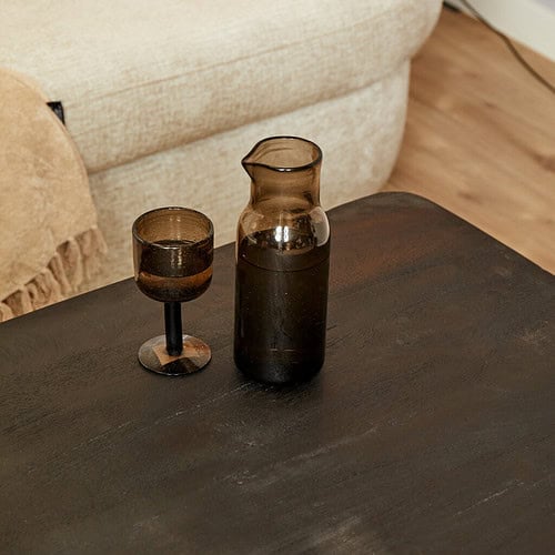 Rustieke glazen karaf en wijn- of waterschaal op massief houten tafel.