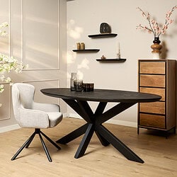 Zwarte houten eettafel met modern design en stevige X-poten in een stijlvolle interieurset.