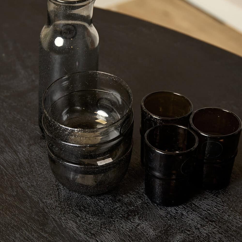Rook glazen en vaas op zwart houten tafel, modern design.