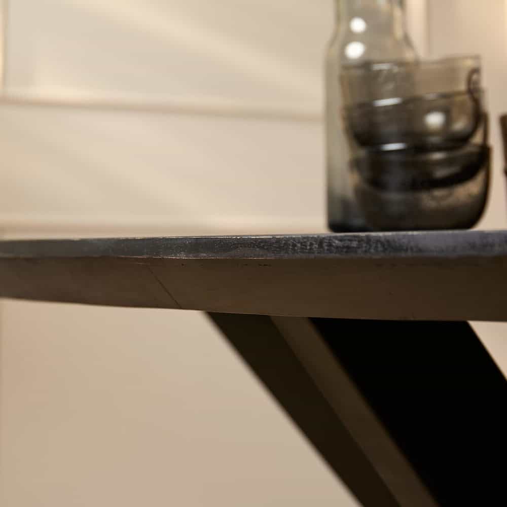 Gebeit houten tafel met zwarte afwerking en glazen vaas, modern interieur accessoire.