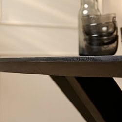 Gebeit houten tafel met zwarte afwerking en glazen vaas, modern interieur accessoire.