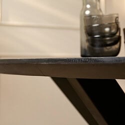 Robuuste houten tafel met zwart afgewerkte rand, modern industrieel design, elegance en functionaliteit in huis of kantoor.