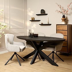 Moderne eetkamertafel met zwart houten tafelblad en sculpturale zwarte ijzeren onderstel, gecombineerd met comfortabele lichte beige eetstoelen, perfect voor een stijlvolle woonkamer of eetruimte.