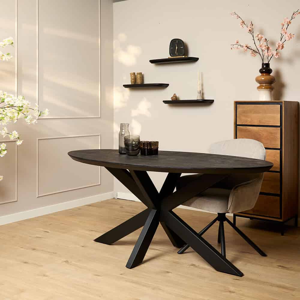 Elegante eettafel met houten blad en zwart metalen onderstel, gecombineerd met een comfortabele gebroken witte eetkamerstoel, gelegen in een modern interieur met decoratieve accessoires en wandplanken, perfect voor een stijlvolle eetruimte.