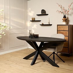 Elegante eettafel met houten blad en zwart metalen onderstel, gecombineerd met een comfortabele gebroken witte eetkamerstoel, gelegen in een modern interieur met decoratieve accessoires en wandplanken, perfect voor een stijlvolle eetruimte.