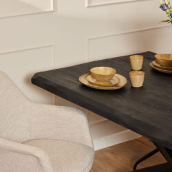 Stijlvolle eetkamertafel met een zwart marmeren blad en modern beige gestoffeerde stoel, perfect voor een luxe en gezellige eetruimte, geleverd door Mokana Meubelen.