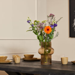 Klassieke bloemenvaas met kleurrijke bloemen op eettafel, modern decor accessoires, stijlvolle interieur inspiratie, ruwe houten tafel, elegante woonkamer styling, Mokana Meubelen, hoogwaardige meubelstijl.