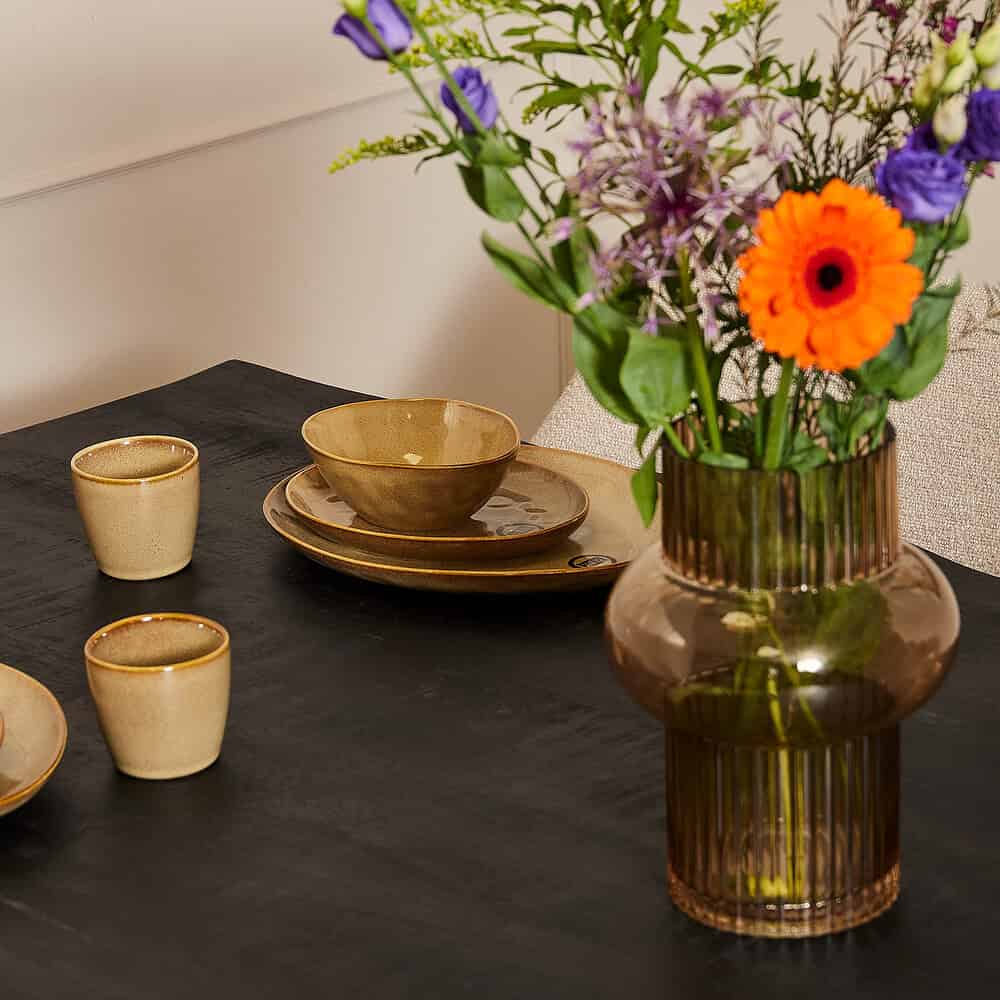 Elegante keramische servies en bloemvazen voor een stijlvolle eet- en woonruimte, passend bij moderne en landelijke interieurstijlen.