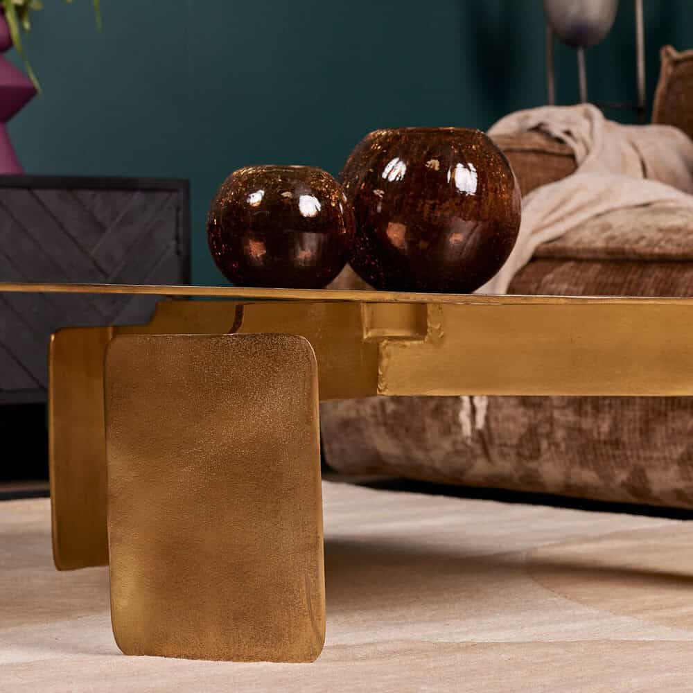 Elegante bronzen decoratieve vazen op een goudkleurige salontafel in een modern interieur.