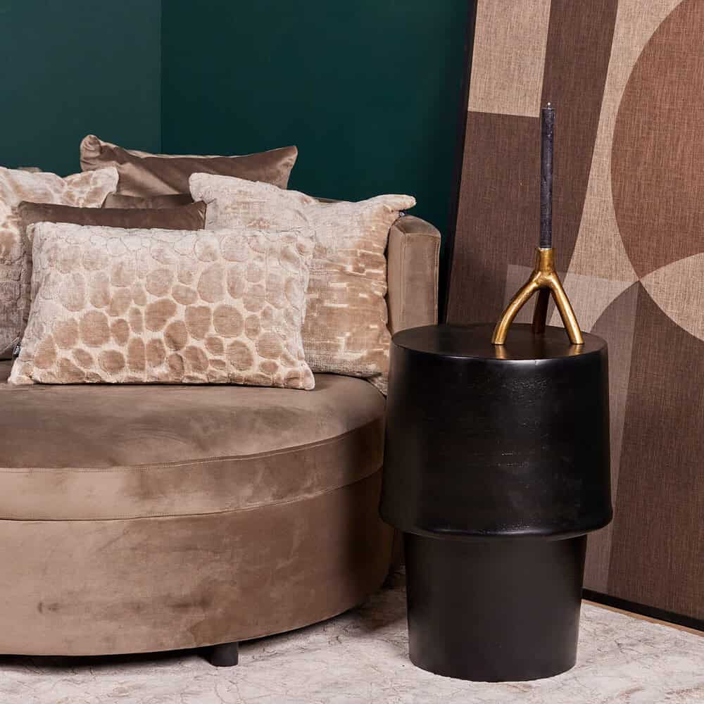 Stijlvolle bank met luxe sierkussens en moderne bijzettafel in een elegant interieur, perfect voor een comfortgerichte sfeer.