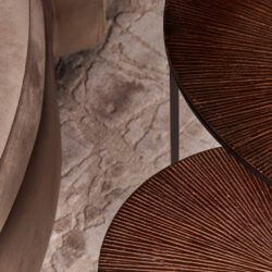 Sfeervolle close-up van een elegante, ronde houten tafel met structuur en warme afwerking, onderdeel van de Mokana Meubelen collectie voor stijlvolle interieurs.