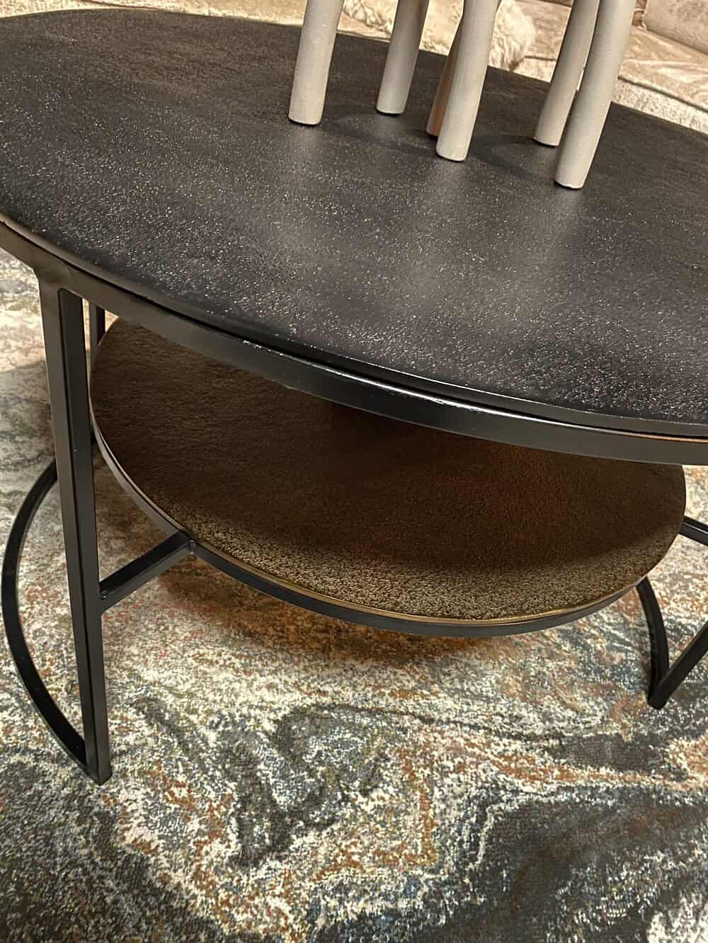 Minimalistisch zwart metalen eettafel met een zwart tafelblad en een stroken rustieke onderlegger, perfect voor moderne en industriële interieurstijlen.