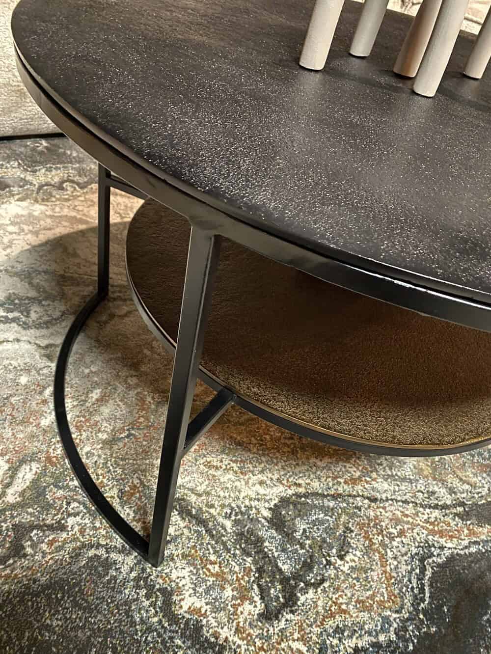 Elegante metalen bijzettafel met twee lagen, zwart afwerking en een moderne, minimalistische uitstraling, ideaal als accentstuk in elk interieur.