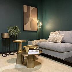 Elegante woonkamer inrichting met luxe metalen bijzettafels, modern vloerlamp en een comfortabele bank, gecombineerd met decoratieve kussens en kunst aan de muur, perfect voor stijlvolle interieurs.