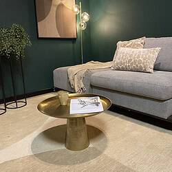 Modern uitgesneden salontafel van bronskleurig metaal in een woonkamer setting.