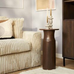 Grote houten bijzettafel in een modern woonkamer met decoratieve kandelaars en textuurarm banken. Mokana Meubelen specialiseert zich in hoogwaardige, stijlvolle meubels op maat voor elke inrichting.