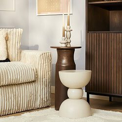 Houten bijzettafel met kandelaar op muur in woonruimte.