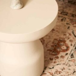 Minimalistisch bijzettafel in beige met afgeronde hoeken, perfect voor modern interieur, gecombineerd met houten vloer en decoratieve steen voor een stijlvolle uitstraling.