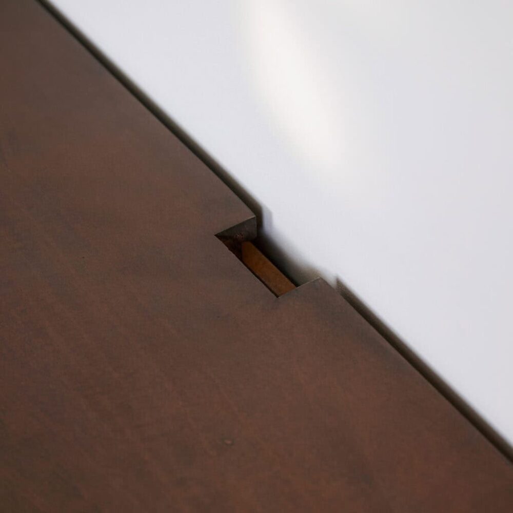 Strakke eethoek tafel in donker hout met verfijnd ontwerp, beschikt over engsel voor optimale stabiliteit en uitstraling.