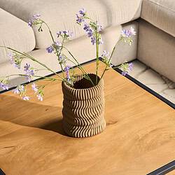 Gezicht op een decoratieve, textuurrijke keramieken vaas met bloemen op een houten salontafel in een moderne woonkamer. Perfecte meubelstijl inspiratie met natuurlijke materialen en stijlvolle accessoires.