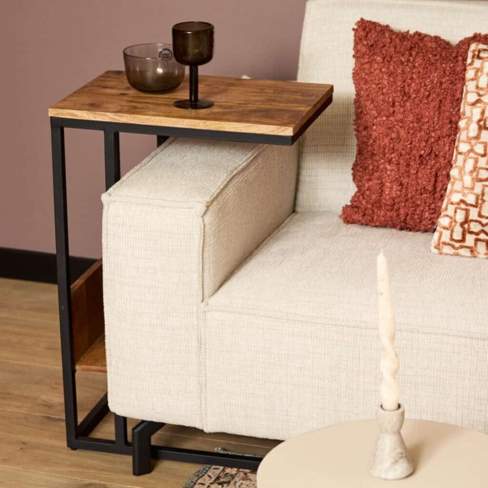 Houten bijzettafel naast beige bank met kussen, modern interieur design, warme woonstijl, hout en metaal, stijlvolle woonkamers, interieuraccessoires, woonkamer decoratie, functioneel meubel, stijlvolle woonideeën, warme woonstijl.